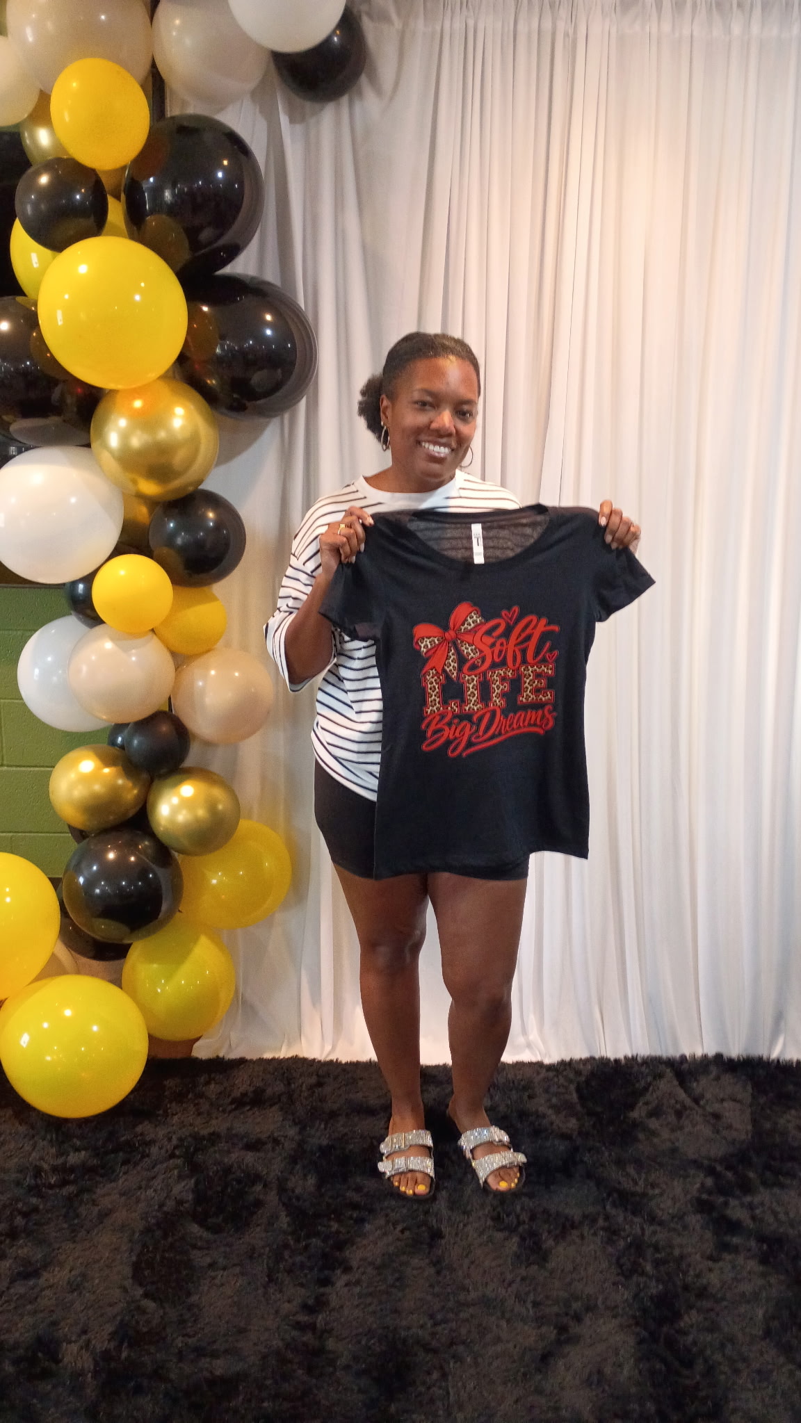 Guest smiling and displaying her completed custom event shirt